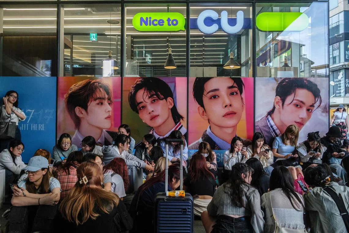 Fans queue up to buy the new album '17 is Right Here', by South Korean boy band Seventeen (or SVT), outside a convenience store in the trendy Hongdae neighbourhood of Seoul on April 29, 2024, on the day of the album's official release. (Photo by ANTHONY WALLACE / AFP)