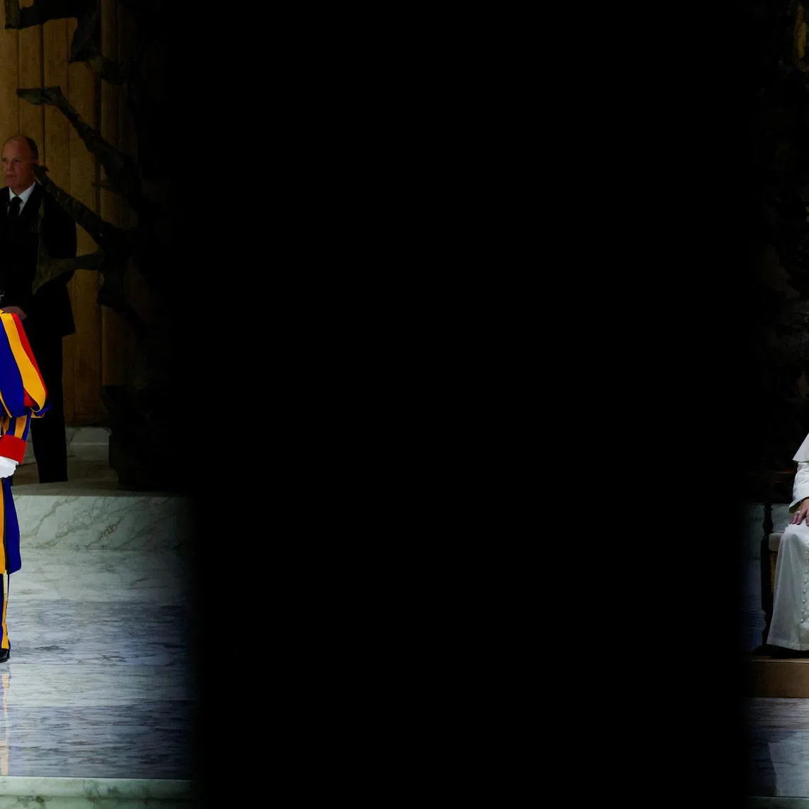 Pope Leo XIV sits as a Swiss Guard stands during the weekly general audience at the Paul VI hall at the Vatican, February 4, 2026. REUTERS/Remo Casilli