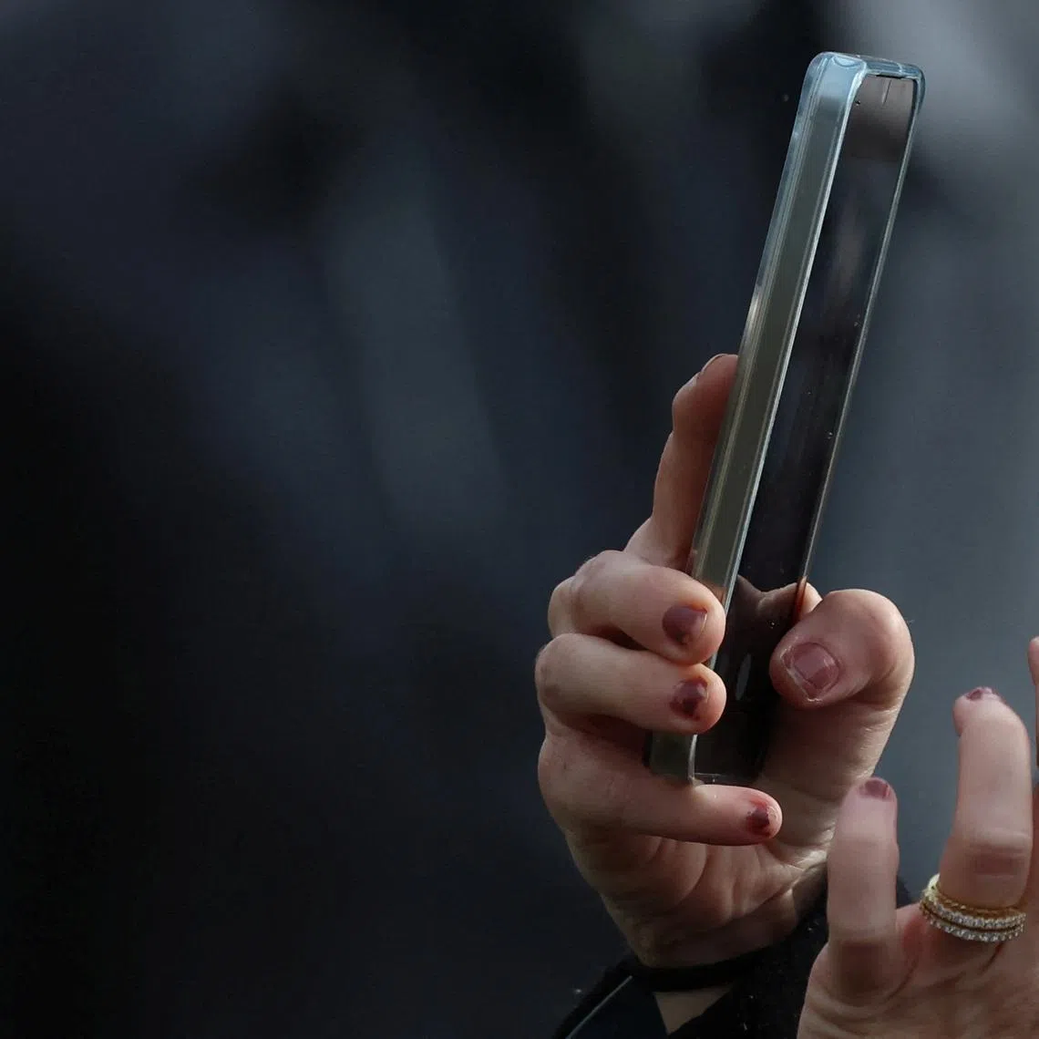 A woman uses a smartphone to take a photograph in Liverpool, Britain, October 8, 2024. REUTERS/Phil Noble