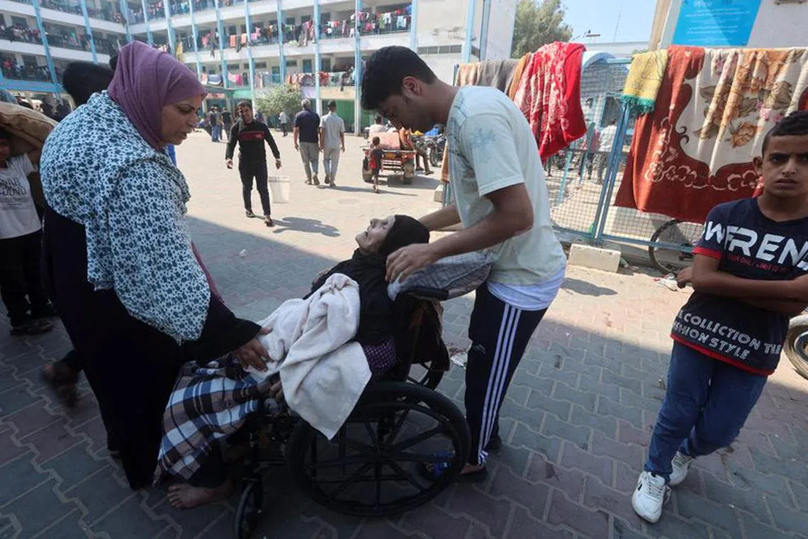 Palestinians, who fled their houses amid Israeli strikes, shelter at a United Nations-run school, after Israel's call for more than 1 million civilians in northern Gaza to move south, in Khan Younis in the southern Gaza Strip, October 14, 2023. REUTERS/Ahmed Zakot