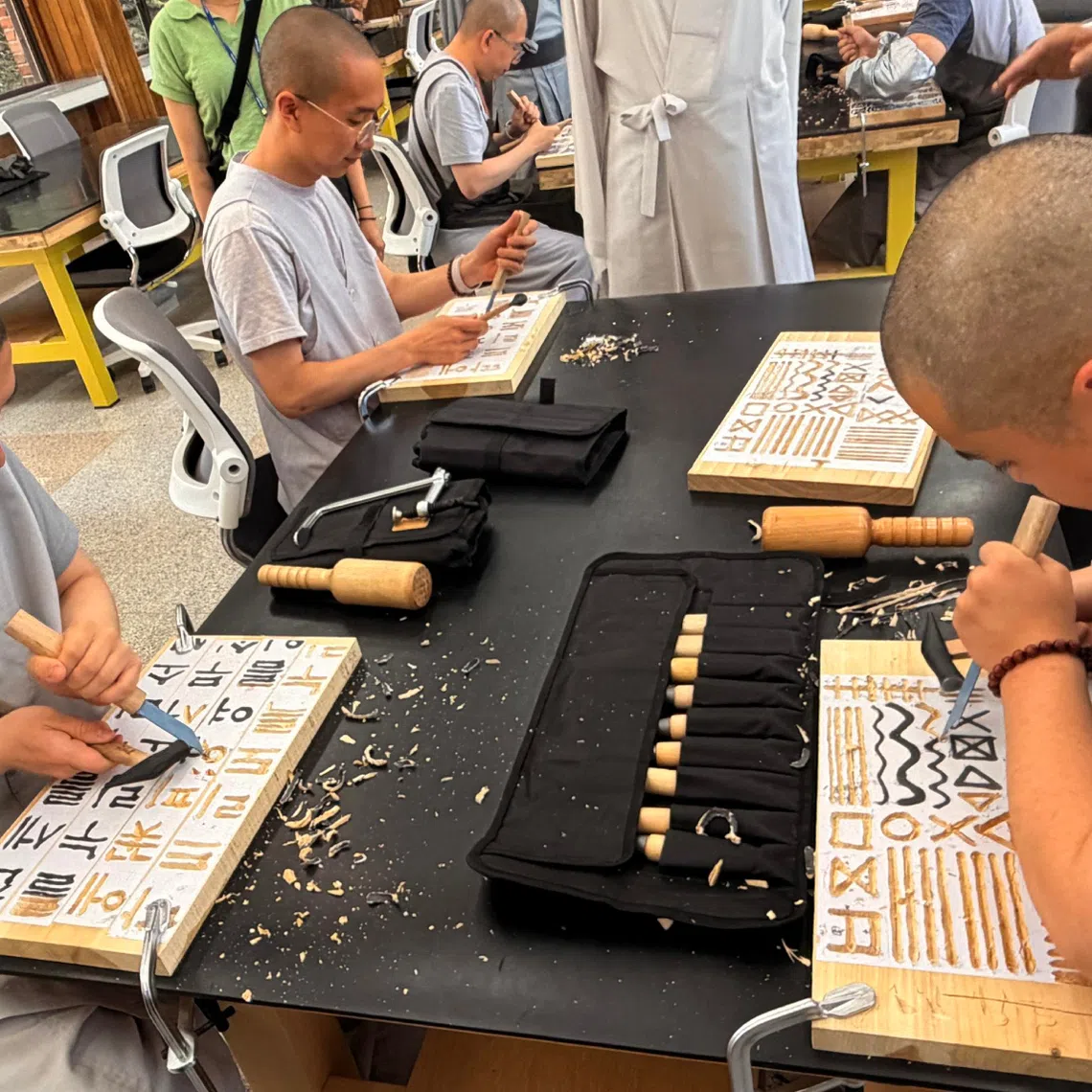 Beginner woodcarving. Woodcarving beginners start off by carving lines and shapes, before moving on to large-sized Hangul characters.