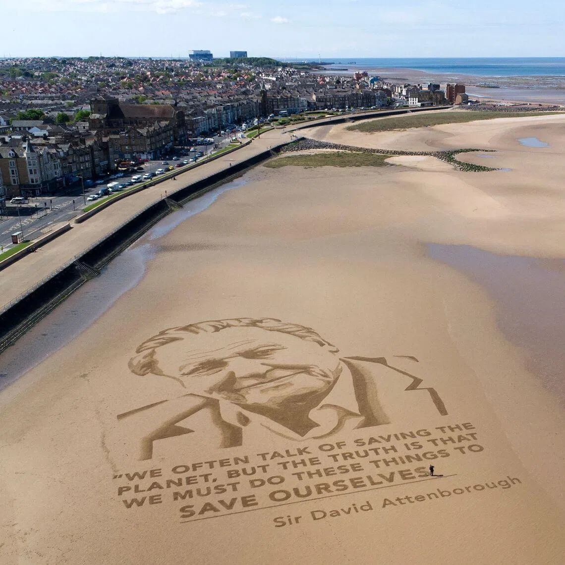 This aerial photograph taken on May 6 shows a sand drawing of David Attenborough by the arts organisation Sand In Your Eye, on Morecambe beach, northern England, in celebration of his 100th birthday. 