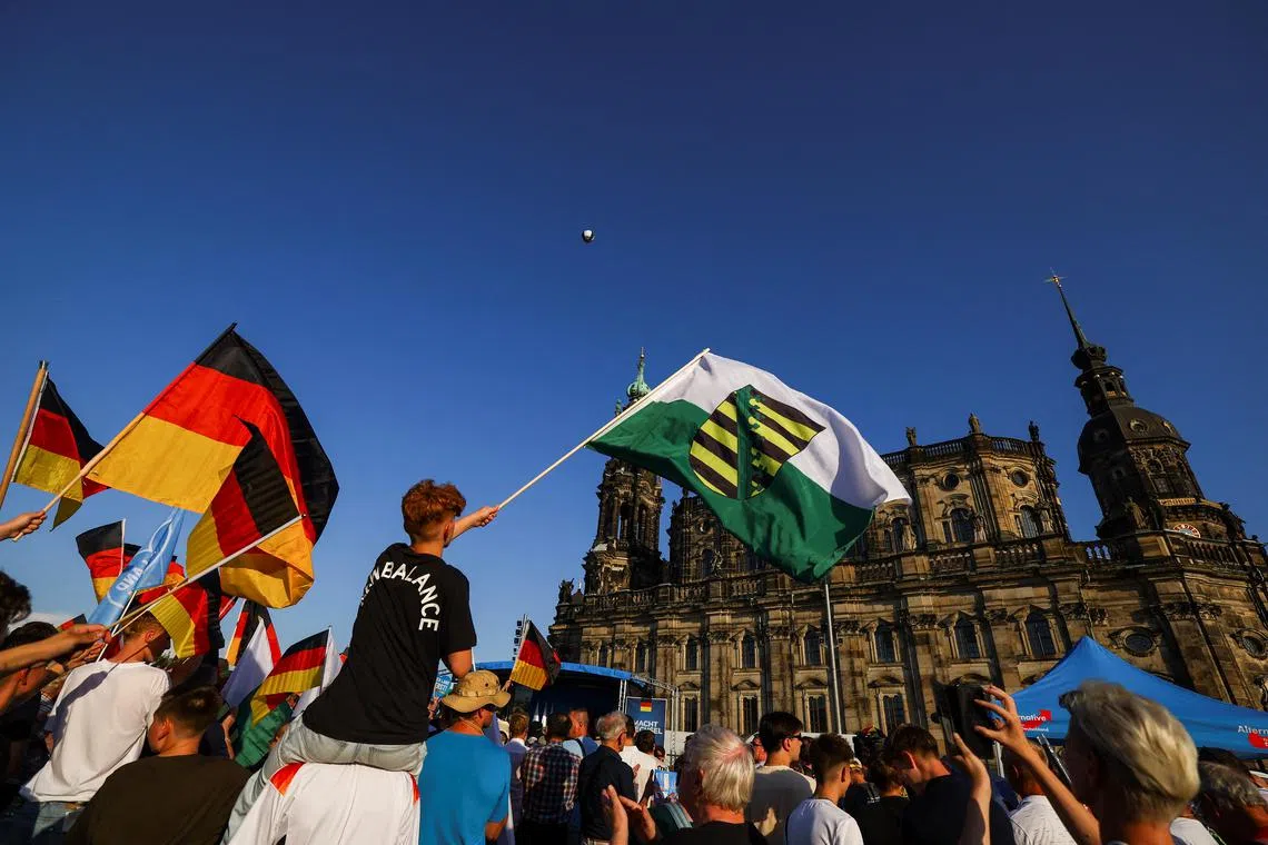 FILE PHOTO: People wave flags on the day of the campaign of Alternative for Germany (AfD) party co-leaders Alice Weidel and Tino Chrupalla for the Saxony state elections in Dresden, Germany, August 29, 2024. REUTERS/Lisi Niesner/File Photo