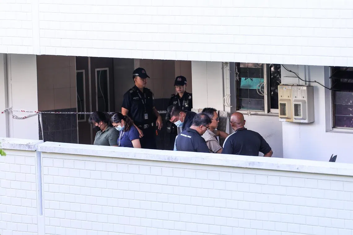 Police officers inspecting the murder scene at a Bukit Panjang flat in 2024.