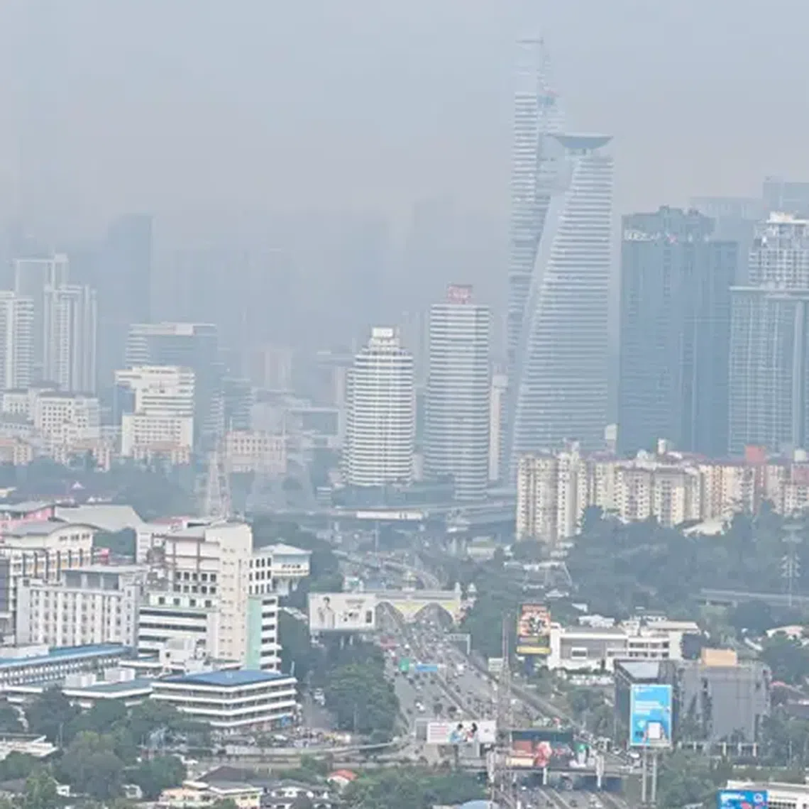 Haze and dense smog obscure the Kuala Lumpur skyline at past noon on July 22, 2025.
