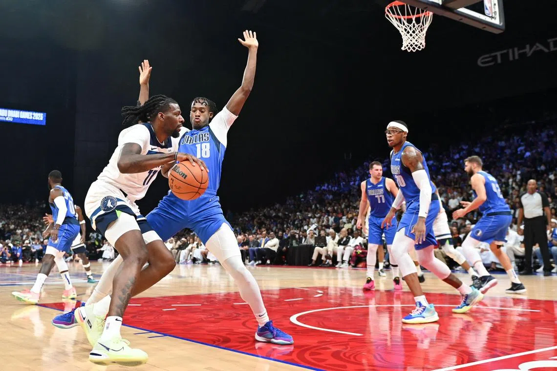 Minnesota Timberwolves forward Naz Reid is guarded by Dallas Mavericks forward Olivier-Maxence Prosper during the NBA pre-season game at the Etihad Arena in Abu Dhabi on Oct 7, 2023. 