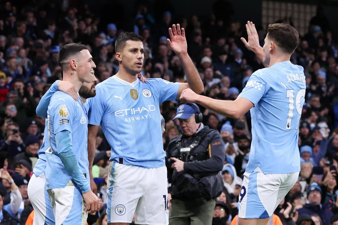 Manchester City's Rodri (centre) celebrates scoring the opening goal with teammate Julian Alvarez.