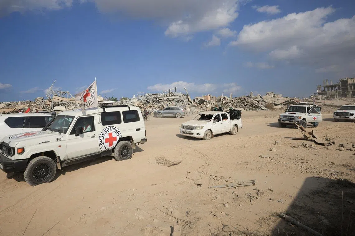 FILE PHOTO: Red Cross personnel, escorted by Hamas militants, wait to head towards an area within the so-called \"yellow line\" to which Israeli troops withdrew under the ceasefire, as Hamas says it continues to search for the bodies of deceased hostages seized during the October 7, 2023, attack on Israel, in Gaza City November 12, 2025. REUTERS/Dawoud Abu Alkas/File Photo