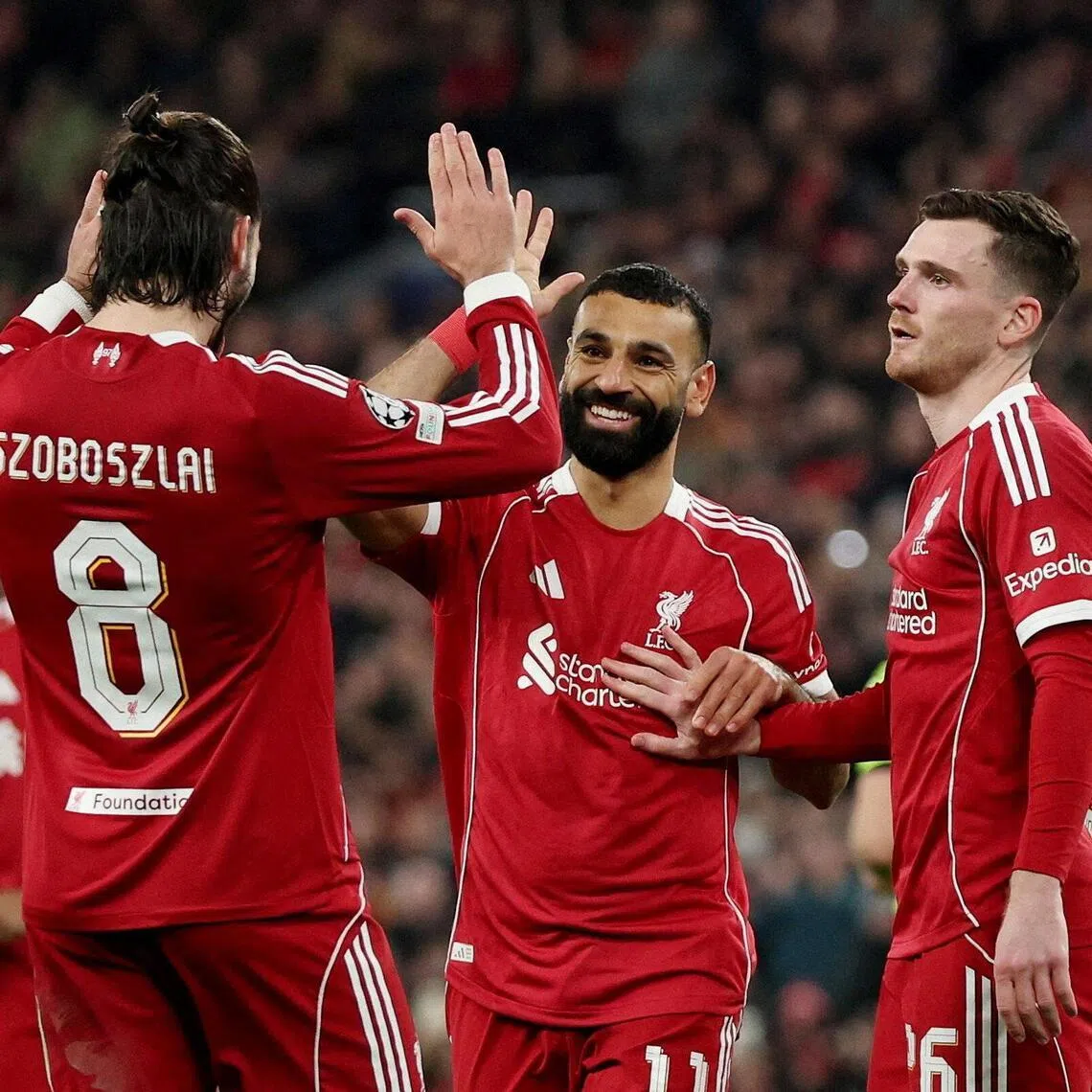 Liverpool's Mohamed Salah celebrates scoring their third goal with teammates.