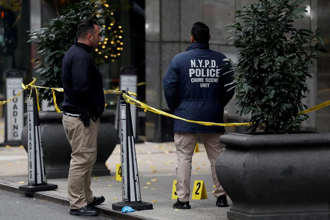 FILE PHOTO: Law enforcement officers work near evidence markers placed where shell casings were found at the scene where the CEO of UnitedHealthcare Brian Thompson was shot and killed in Midtown Manhattan, in New York City, US, December 4, 2024.REUTERS/Shannon Stapleton/File Photo