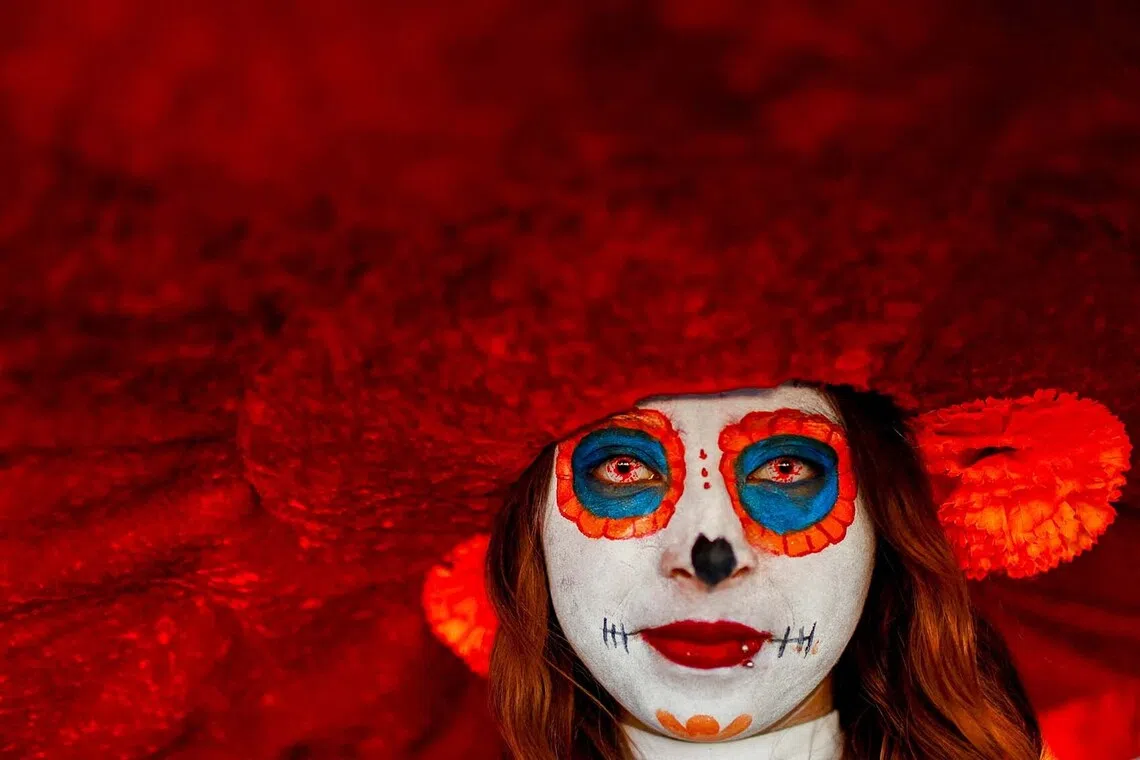A woman dressed as a "Catrina" poses for a picture at the Day of the Dead mega offering to honor the 700th anniversary of the founding of Tenochtitlan at Zocalo Square, in Mexico City, Mexico, October 27, 2025. REUTERS/Raquel Cunha TPX IMAGES OF THE DAY