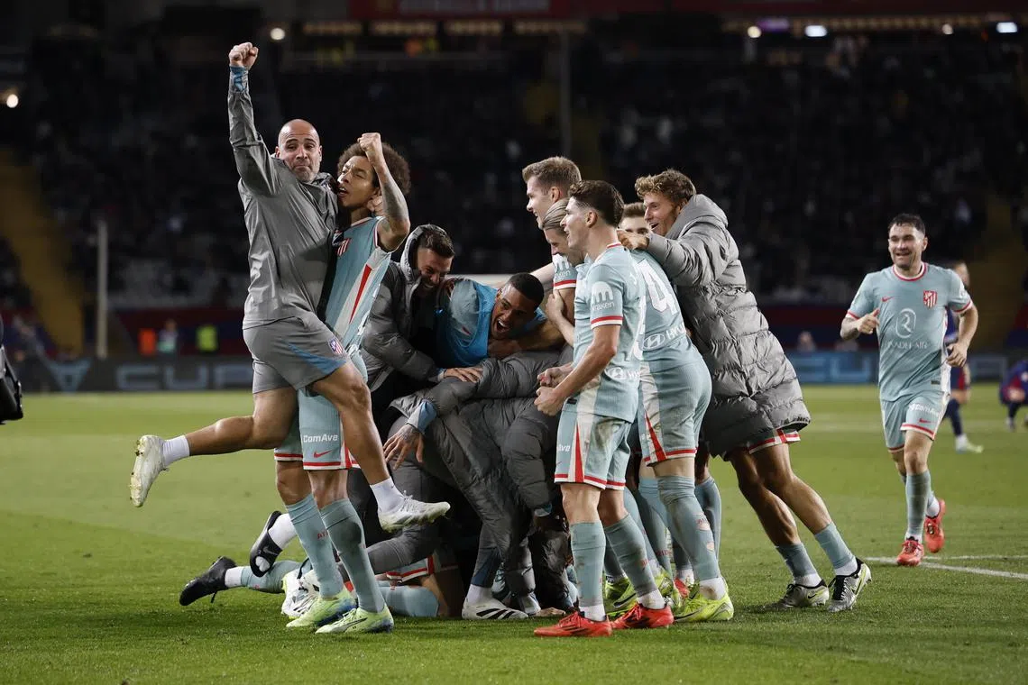 Atletico Madrid's players celebrate beating Barcelona 2-1 in La Liga match at the Estadi Olimpic Lluis Companys in Barcelona on Dec 21.