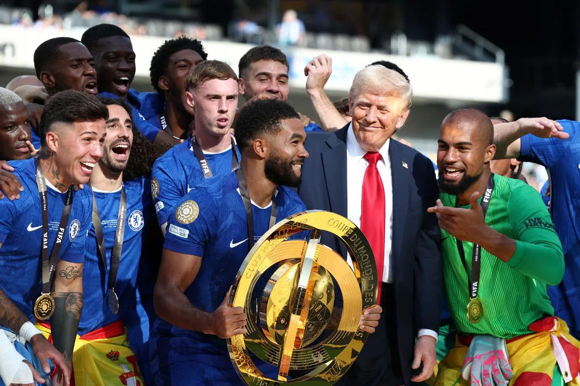 Chelsea's Reece James holds the trophy as he celebrates with teammates and U.S. President Donald Trump after Chelsea won against Paris St Germain in the FIFA Club World Cup final, at the MetLife Stadium in East Rutherford, New Jersey, U.S., July 13, 2025. REUTERS/Kevin Lamarque/Pool
