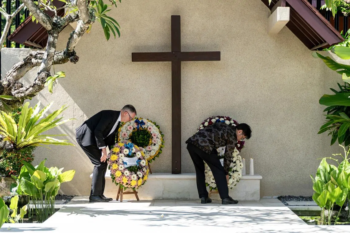 British Consul-General Nigel Greetham (left) and Japanese Consul-General Miyakawa Katsutoshi (right) place wreaths during a memorial service held to mark the 20th anniversary of the 2005 Bali bombings.