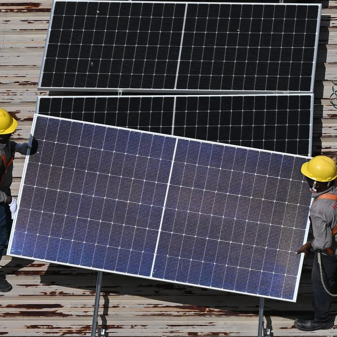 Workers installing solar panels on the rooftop of Block 850 Tampines Street 82 as part of HDB's SolarNova Programme on Nov 20, 2023. The SolarNova programme is a Whole-of-Government effort led by the Economic Development Board and HDB intended to prompt demand for solar photovoltaic systems to achieve economies of scale and to drive growth in Singapore's solar industry. It appeals to public sector demand for the installation of solar panels across 1198 HDB blocks and 57 government sites with a solar capacity of 70 megawatt-peak.