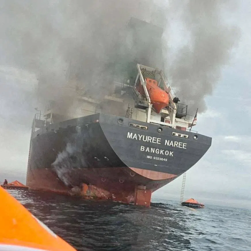 The Thailand-flagged cargo ship Mayuree Naree engulfed in black smoke in the Strait of Hormuz.