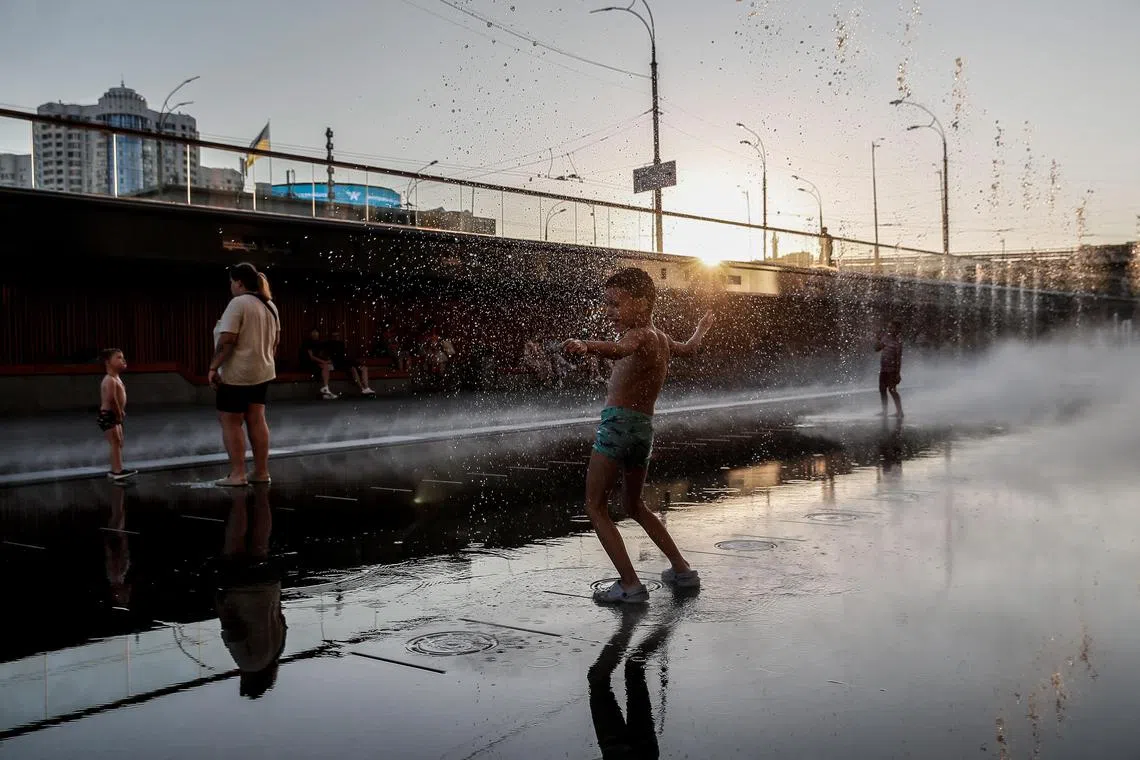 Children play in a fountain on the square in downtown Kyiv, Ukraine, on Aug 17, 2023. 
