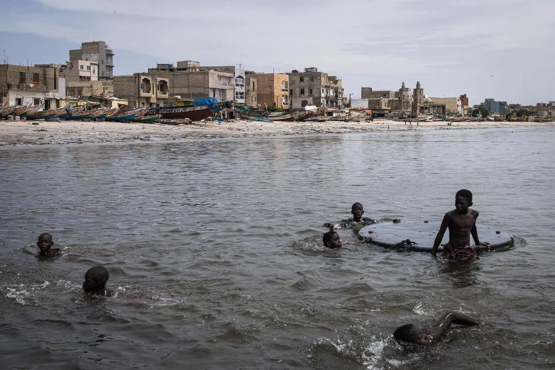 Young boys swimming along the polluted Hann Bay in Dakar, on Sept 27.