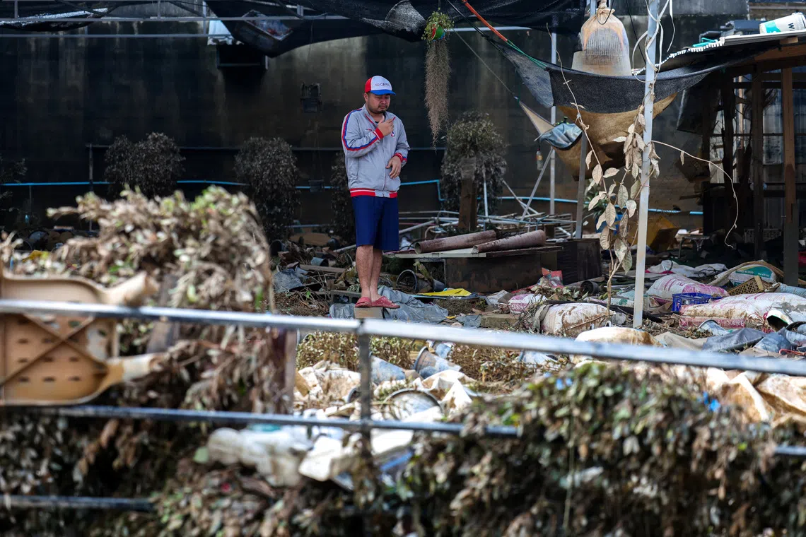 A man stands amid debris in a flooded area in Hat Yai district, Songkhla province, Thailand, November 28, 2025. REUTERS/Athit Perawongmetha