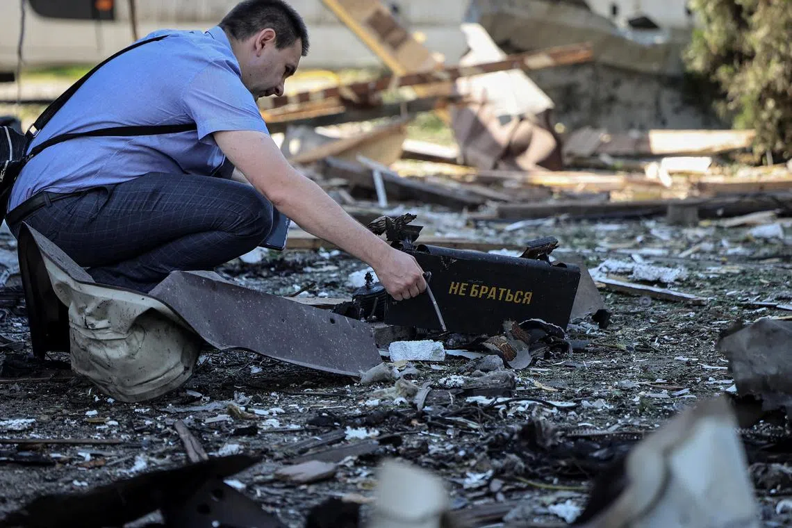 A war crimes prosecutor working at the site of a Russian drone attack, in Lviv, Ukraine, in June 2024.