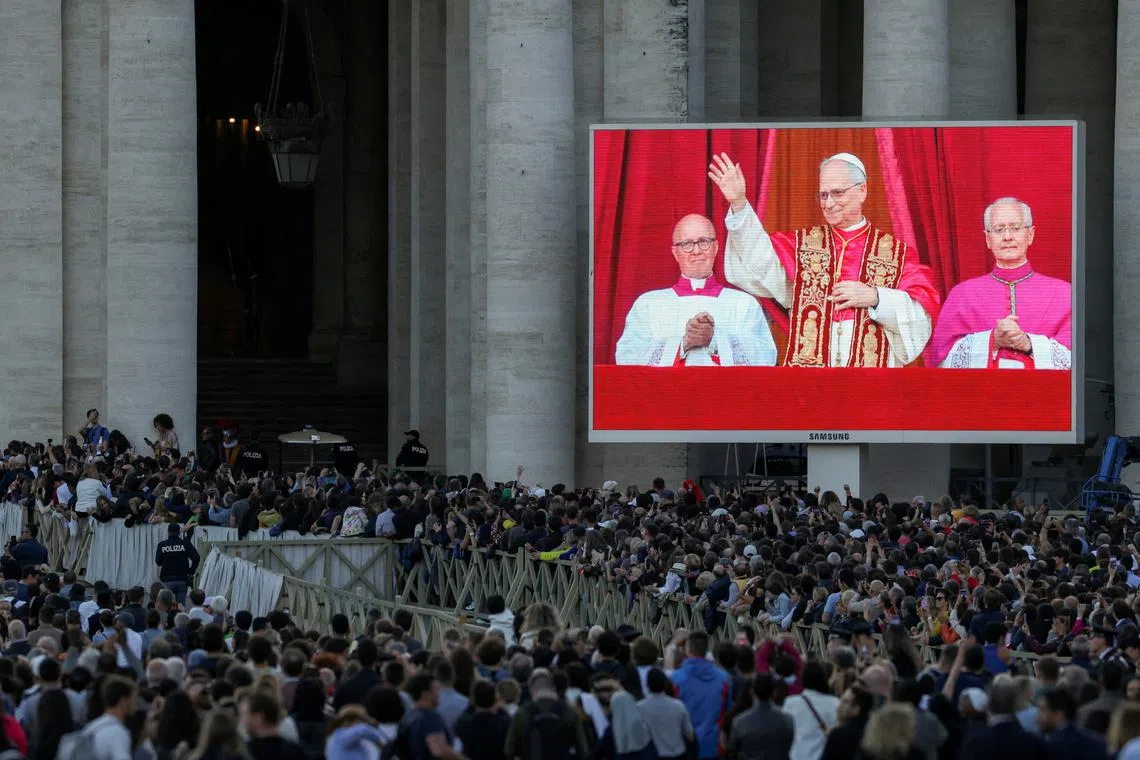 People watch as newly elected Pope Leo XIV, Cardinal Robert Prevost of United States, shown on screen, appears on the balcony of St. Peter's Basilica, as seen from Rome, Italy May 8, 2025. REUTERS/Alkis Konstantinidis