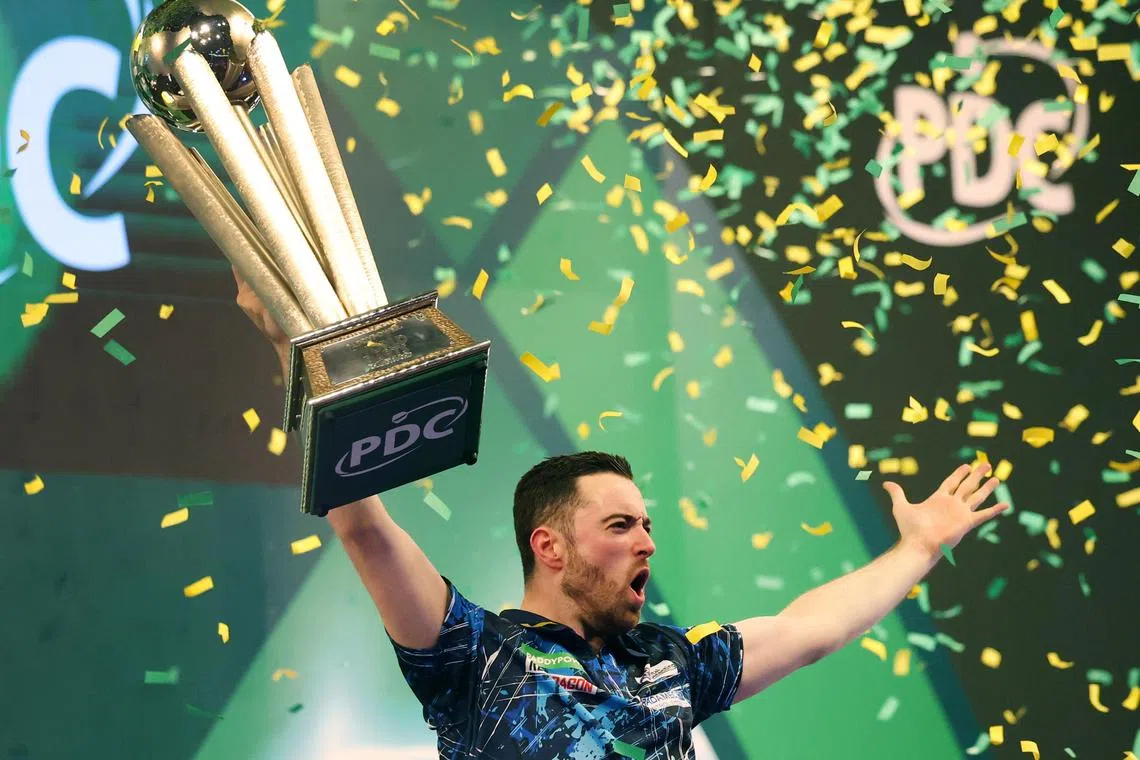 Britain’s Luke Humphries celebrates with the trophy after beating Luke Littler to win the PDC World Darts final, on Jan 3.