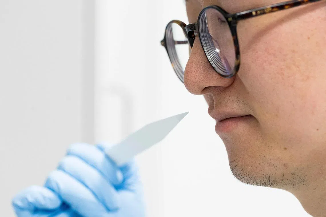Junior perfumer Shangyun Lyu smells a smell strip which is used to evaluate fragrances at Symrise in Holzminden, Germany.