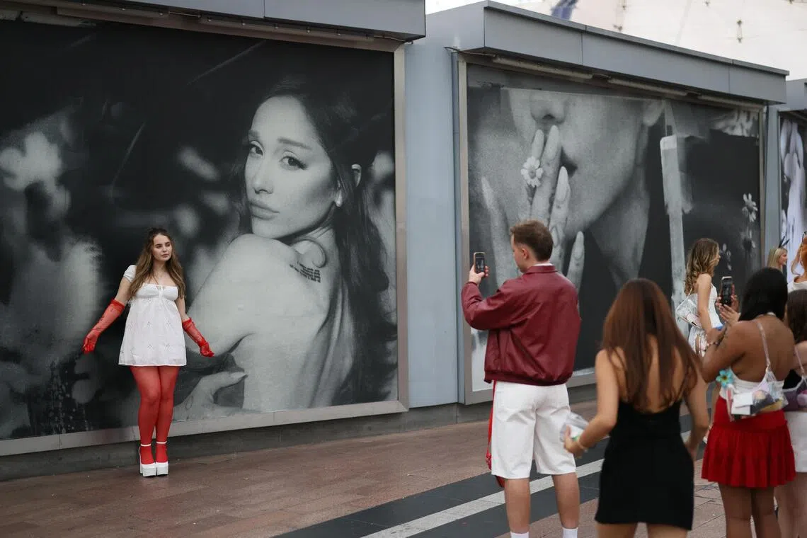 Ariana Grande fans take pictures in front of a billboard as they gather ahead of the opening night of the London leg of the actress and singer's The Eternal Sunshine Tour, in London, Britain, August 15, 2026. REUTERS/Jack Taylor