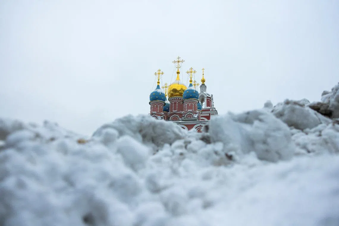 The Church of St. George the Victorious on Pskov Hill is seen behind a heap of snow on a cloudy day in Moscow, Russia, Dec 10, 2024.