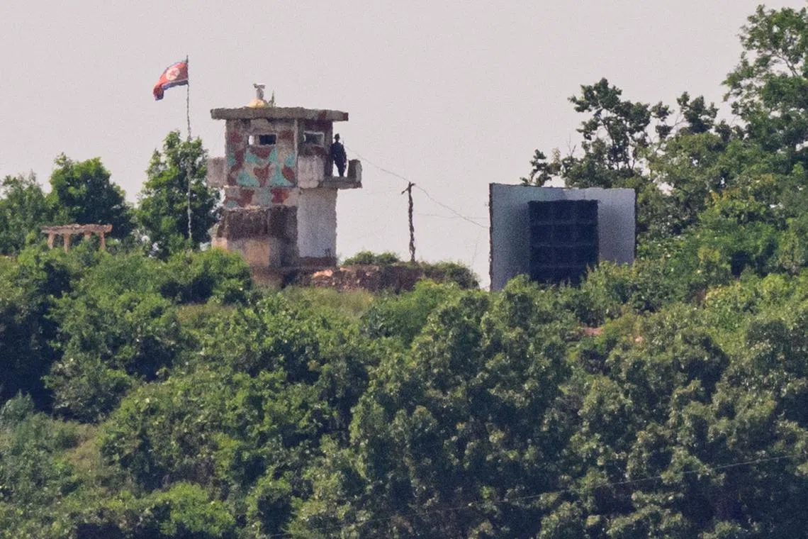 A North Korean soldier stands guard in a watch tower next to a giant loudspeaker (right), near the Demilitarized Zone dividing the two Koreas in Paju on June 12.
