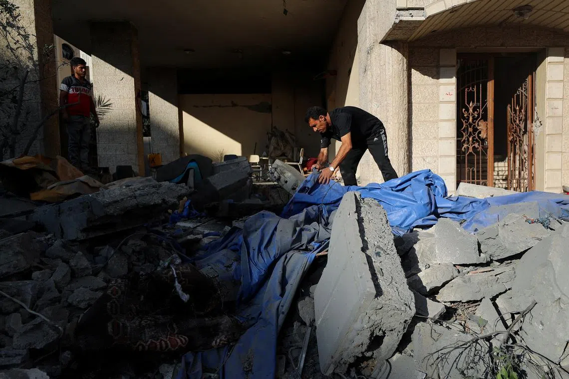 Palestinians inspect the site of an overnight Israeli strike on a house in Gaza City, July 8, 2025. REUTERS/Mahmoud Issa