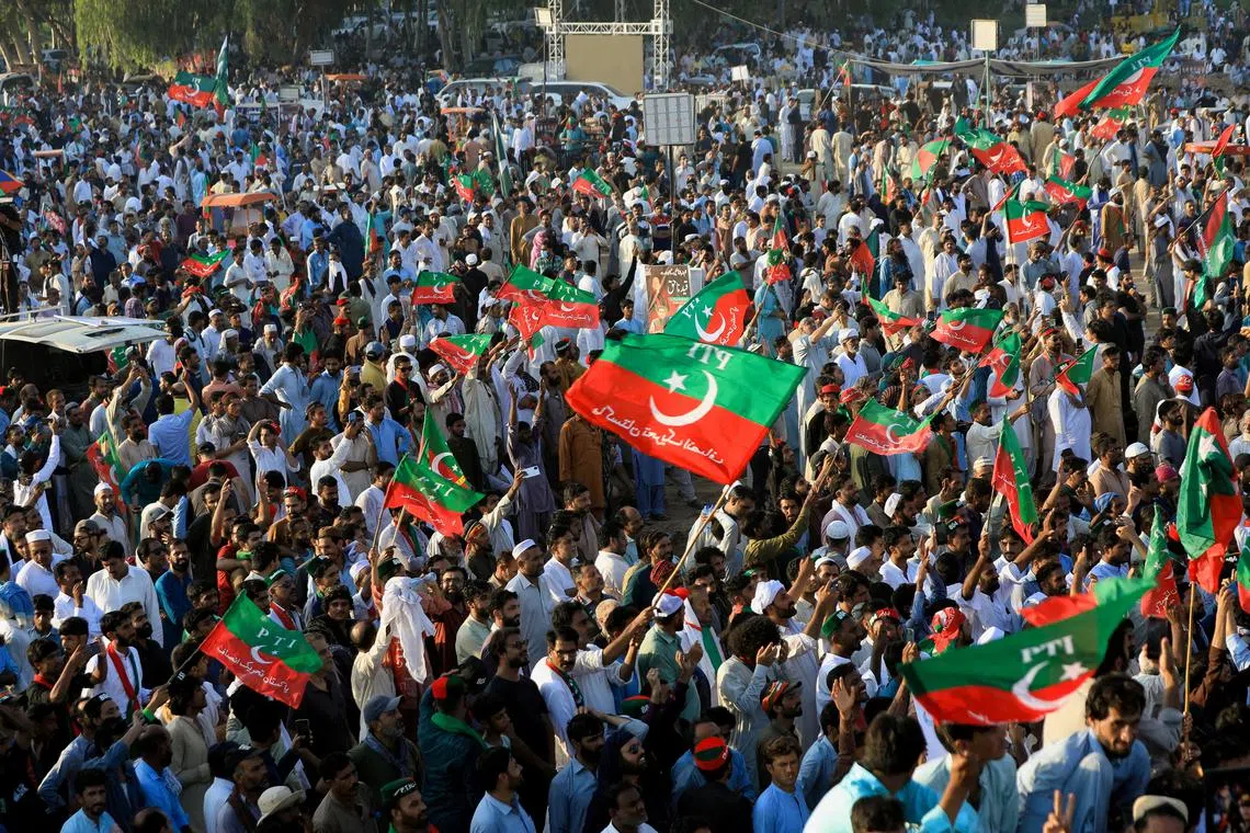 FILE PHOTO: Supporters of jailed former Pakistani Prime Minister Imran Khan's party, the Pakistan Tehreek-e-Insaf (PTI), wave party flags during a rally in Islamabad, Pakistan September 8, 2024. REUTERS/Salahuddin/File Photo