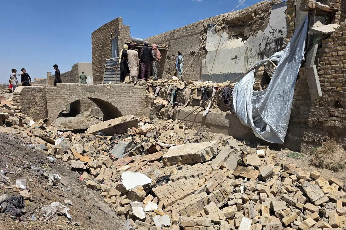 People stand on the rubble of a damaged building that, according to locals residents was damaged in a cross-border shelling by Afghanistan, in Chaman, Balochistan Province, Pakistan on April 28.