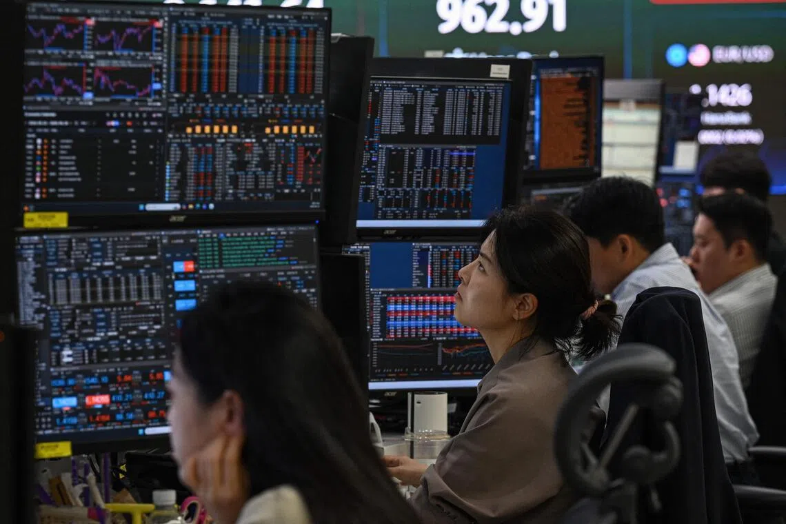 Currency dealers monitor exchange rates in a foreign exchange dealing room at the Hana Bank headquarters in Seoul on June 23.