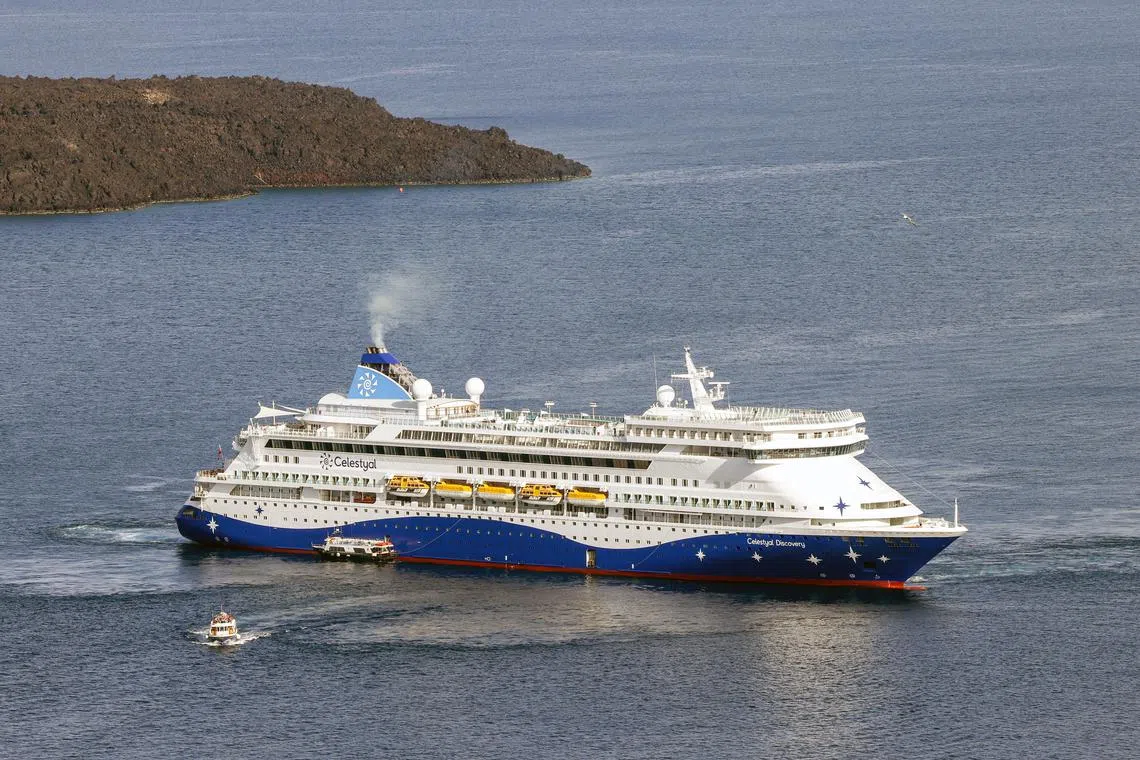 Passengers of cruise ship \"Celestyal Discovery\", the first cruise ship arriving on the island of Santorini following an increased seismic activity that took place in the past month, board ferries to be transferred to the island of Santorini, Greece, March 23, 2025. REUTERS/Stelios Misinas