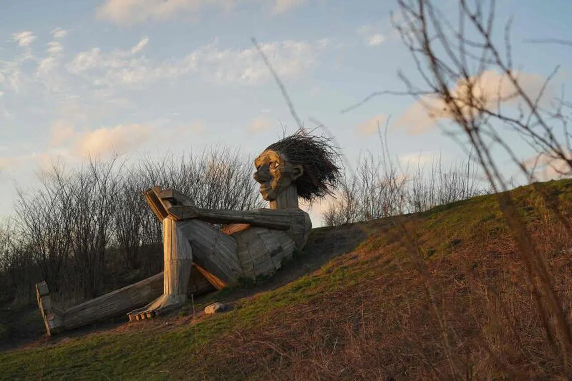 This picture, released on March 28, 2023 show the troll statue ‘Hill Top Trine’ by Danish recycling artist Thomas Dambo. Dambo, best-known for his towering wooden “troll” sculptures, is sending fans on a complex quest to find his recently-completed hundredth troll, one of his fairytale-inspired creations named ‘Moon Mother’.