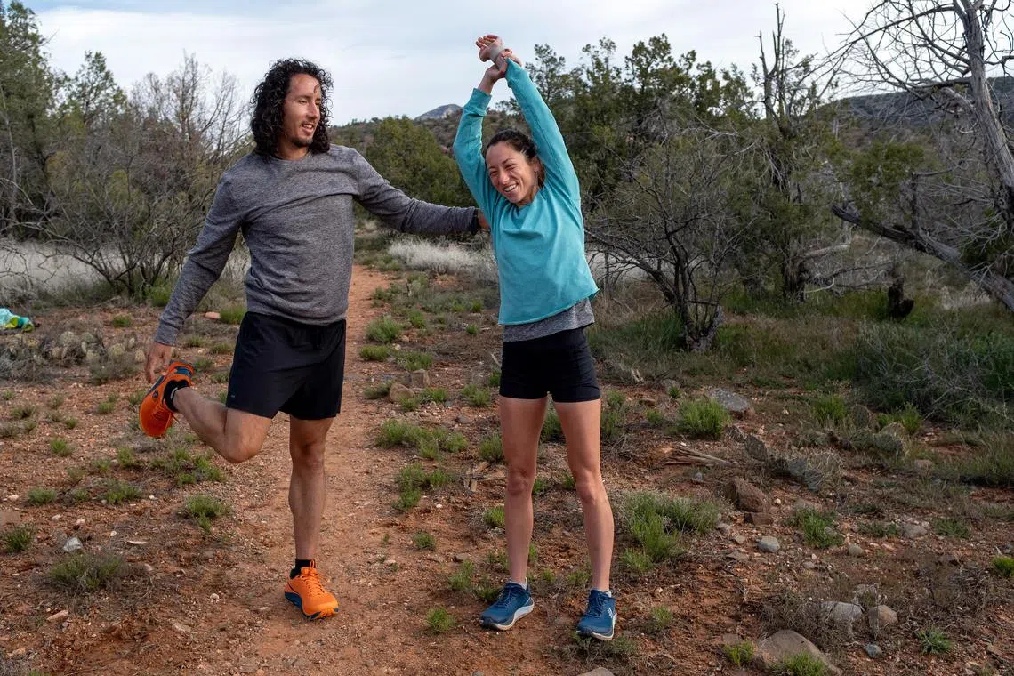 Nickademus de la Rosa and his wife, Jade Belzberg, stretch before a run near Sedona, Ariz.