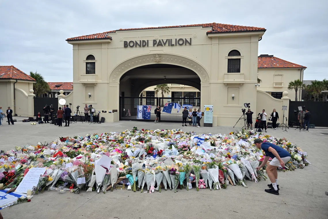 A person lays flowers at a makeshift memorial at Bondi Beach in Sydney, Australia, on Dec 16, 2025.