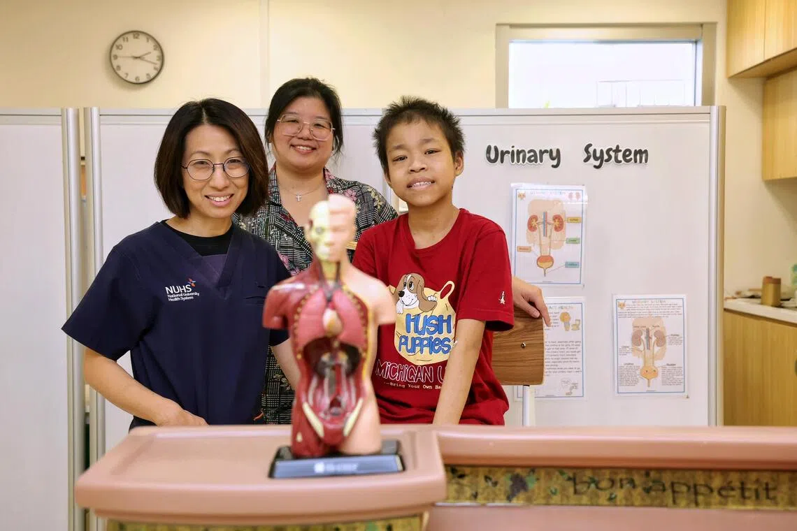Au Wan Rong (right), 16, has a rare mutation in the TRPC6 gene that caused his kidneys to fail. With him are (left) Associate Professor Ng Kar Hui and medical social worker Cheng Peizhi.