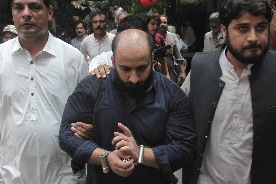 FILE PHOTO: Farhan Asif, who Pakistan's Federal Investigation Agency (FIA) has charged with cybercrime offences for spreading fake online information which fueled riots in Britain, is escorted by the members of FIA outside a court in Lahore, Pakistan, August 22, 2024. REUTERS/Mohsin Raza/File Photo
