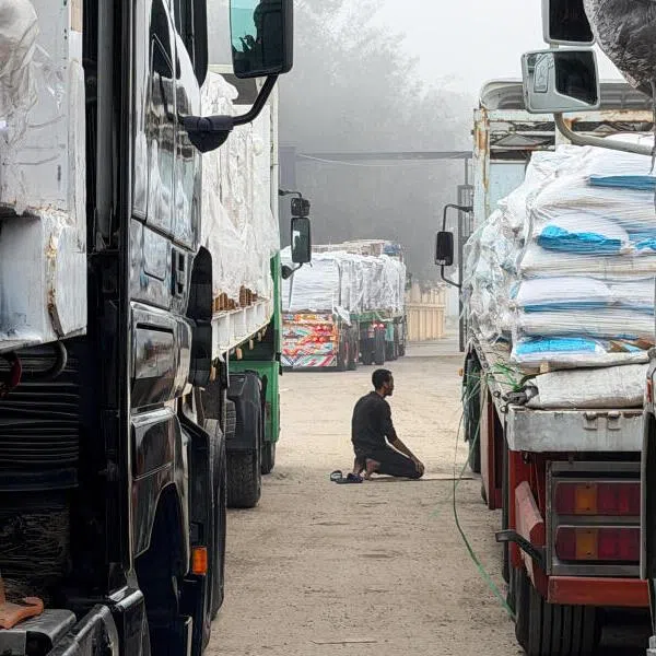 An Egyptian man prays next to trucks carrying humanitarian aid and fuel lined up at the Rafah border to cross into the Gaza Strip, in Rafah, Egypt, on Feb 10.