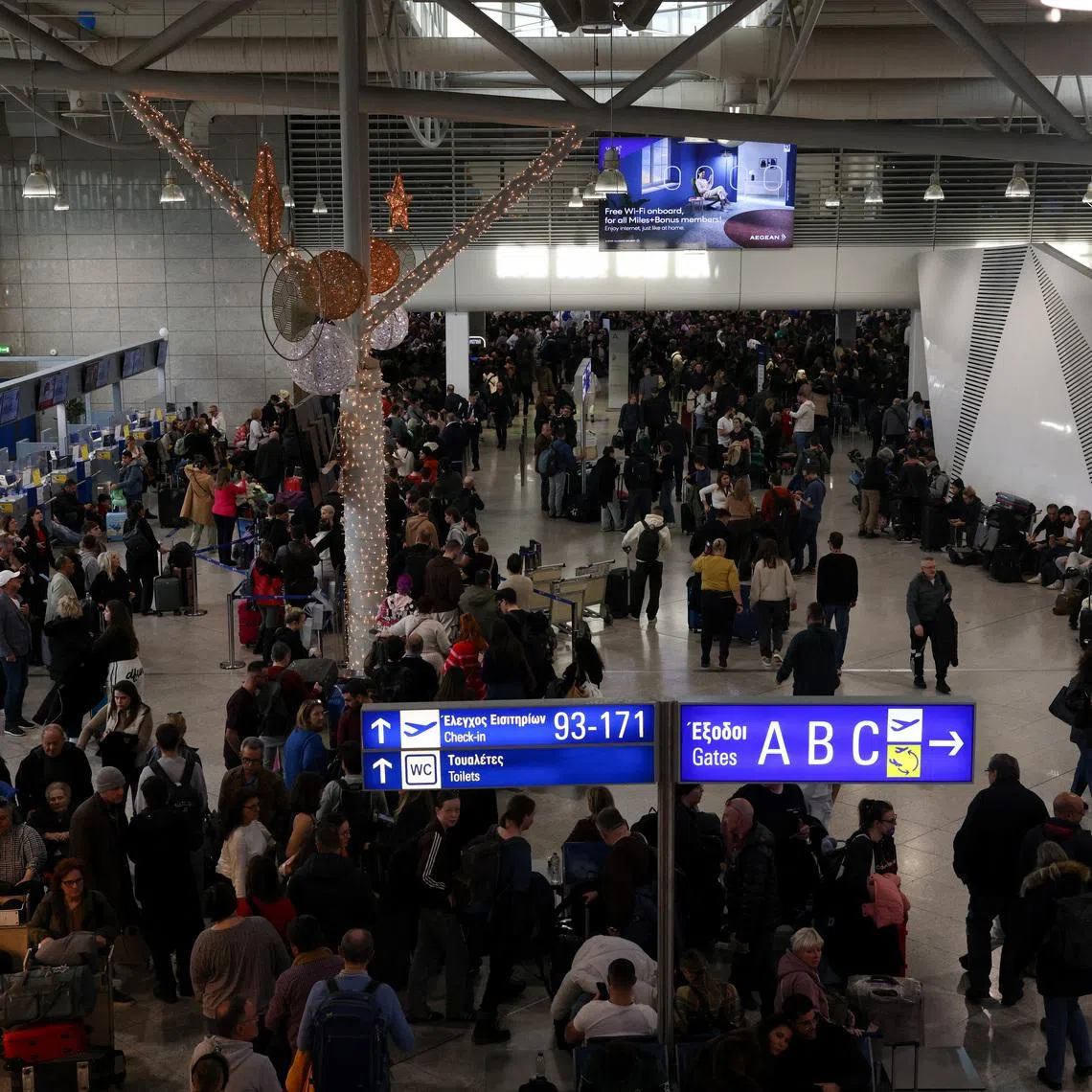 People gather as airports across Greece have suspended arrivals and departures on Sunday, after unspecified issues affecting radio frequencies, at the Eleftherios Venizelos International Airport, in Athens, Greece, January 4, 2026. REUTERS/Louiza Vradi