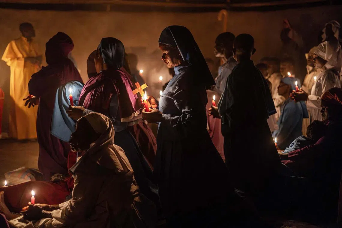 Worshippers of the Legio Maria African Church Mission gathering to pray during the Christmas Eve vigil mass in a church near Ugunja, Kenya, on Dec 24, 2023. 