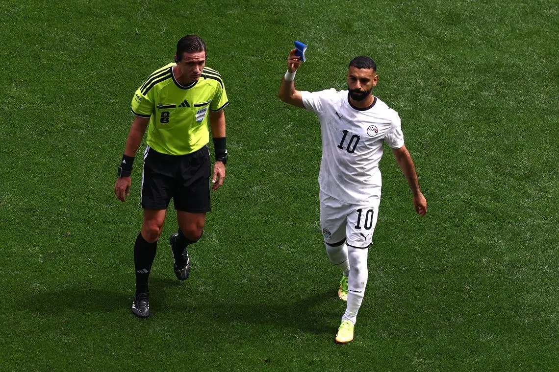 Soccer Football - FIFA World Cup 2026 - Group G - Belgium v Egypt - Seattle Stadium, Seattle, Washington, U.S. - June 15, 2026 Egypt's Mohamed Salah holds up the captains armband as he is substituted as referee Ramon Abatti looks on REUTERS/Lee Smith