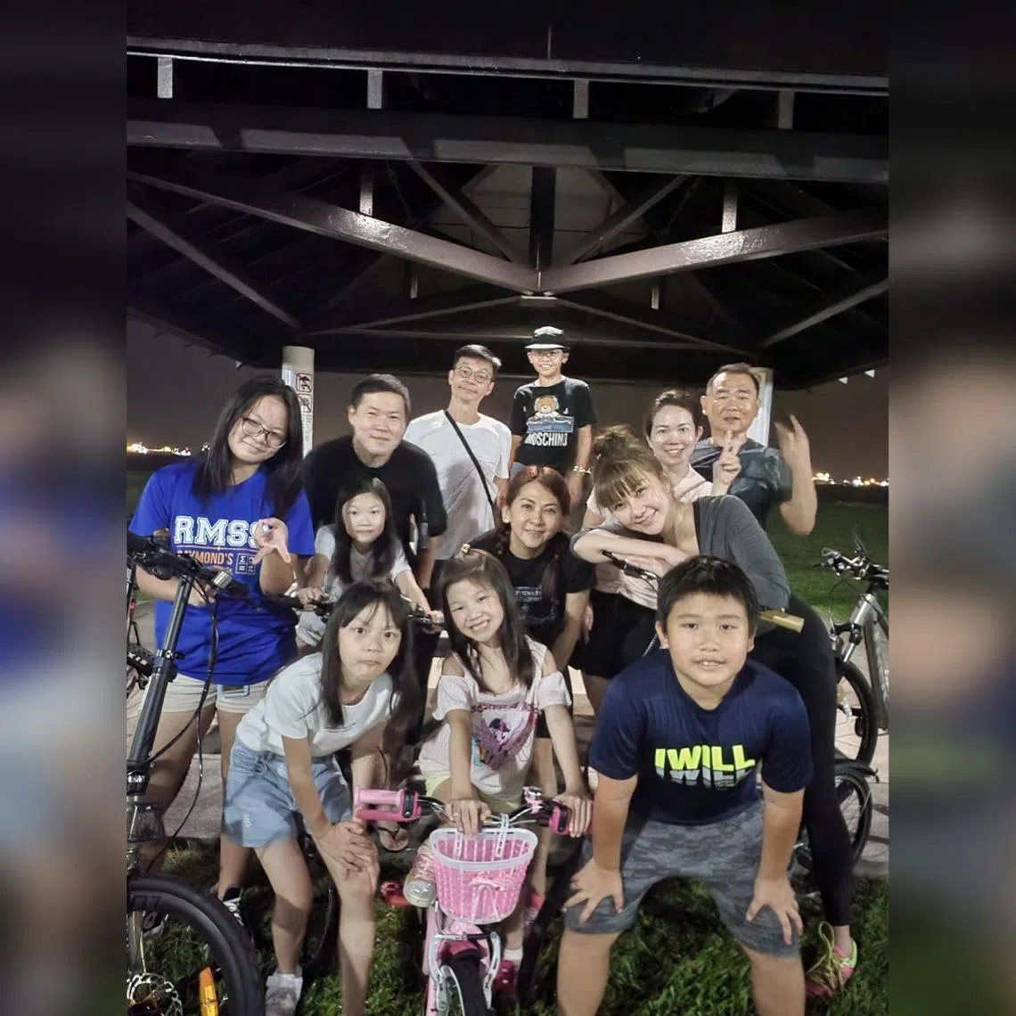 Singaporean actor Mark Lee (background, in white) with his family members and two other families at East Coast Park during one of their weekend night cycling sessions.