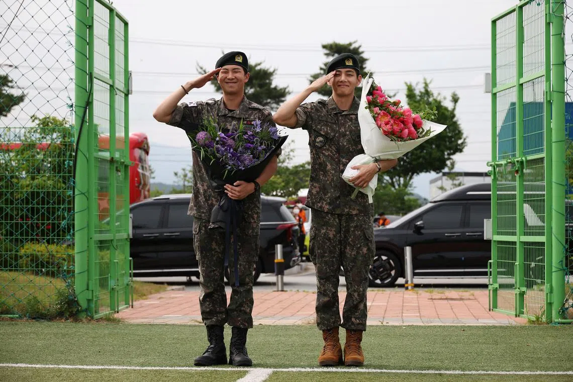 BTS members V and RM, who have been discharged from South Korea’s mandatory military service, pose for photographs during an event in Chuncheon, South Korea on June 10.