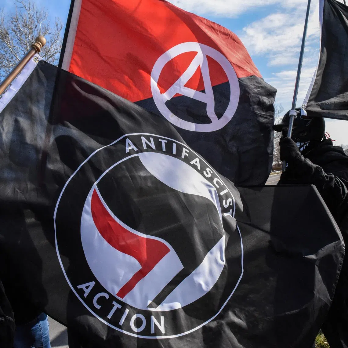 Members of the Great Lakes anti-fascist organization (Antifa) fly flags during a protest against the Alt-right outside a hotel in Warren, Michigan, U.S., March 4, 2018.