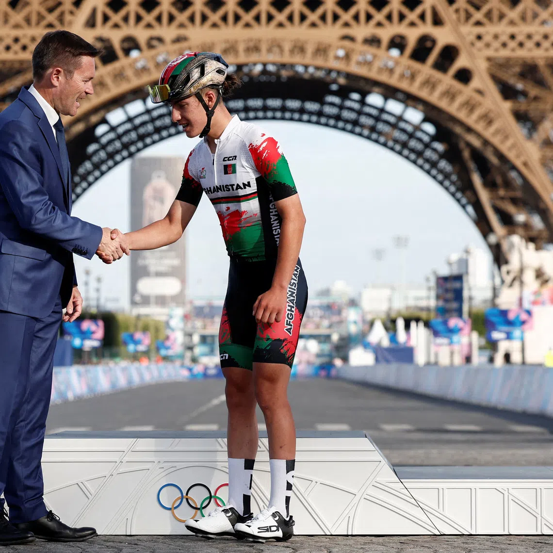 Paris 2024 Olympics - Road Cycling - Women's Road Race Victory Ceremony - Trocadero, Paris, France - August 04, 2024. UCI President David Lappartient shakes hands with Fariba Hashimi of Afghanistan. REUTERS/Benoit Tessier