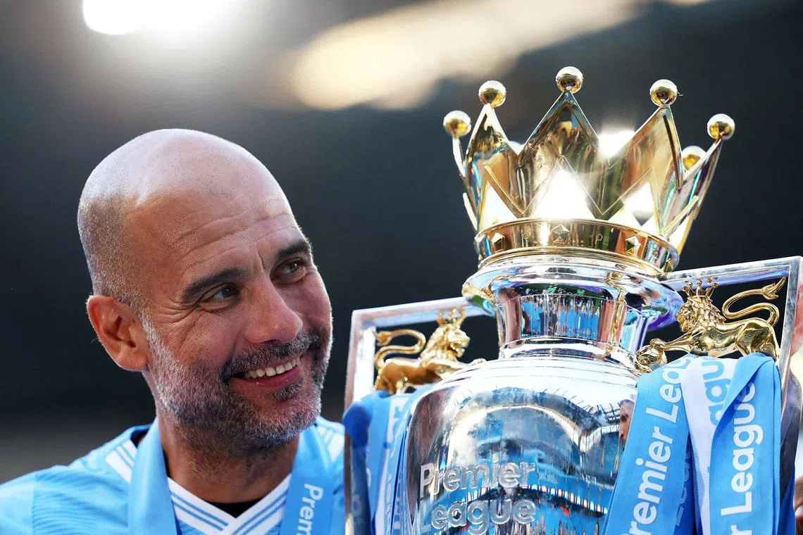 FILE PHOTO: Soccer Football - Premier League - Manchester City v West Ham United - Etihad Stadium, Manchester, Britain - May 19, 2024  Manchester City manager Pep Guardiola celebrates with the trophy after winning the Premier League Action Images via Reuters/Lee Smith