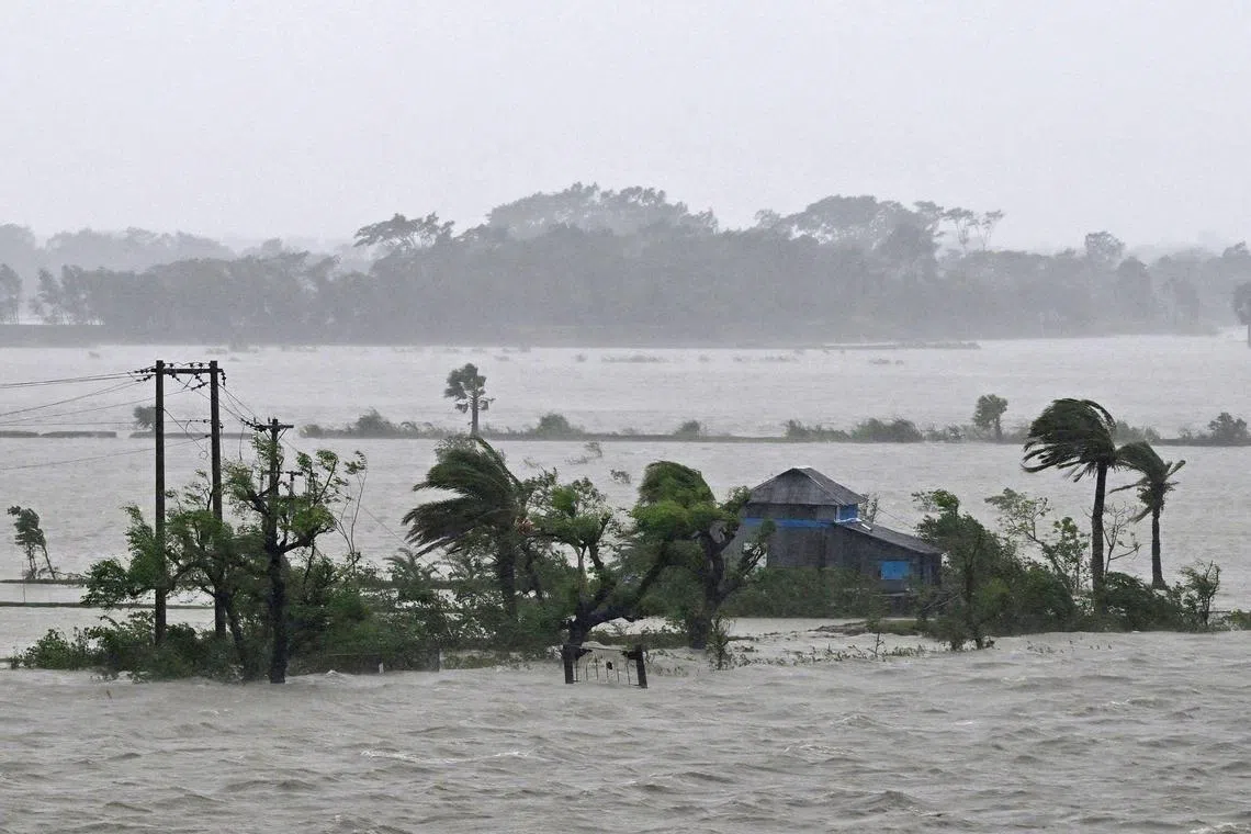 Marooned houses are seen during heavy rainfall in Patuakhali on May 27, 2024, following the landfall of Cyclone Remal in Bangladesh. Residents of low-lying coastal areas of Bangladesh and India surveyed the damage on May 27 as an intense cyclone weakened into heavy storm, with at least two people dead, roofs ripped off and trees uprooted. (Photo by Munir Uz Zaman / AFP)
